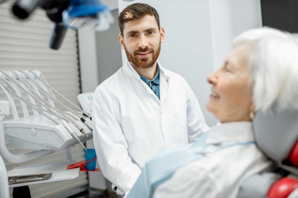 Dentist and patient during a dental consultation and oral exam.