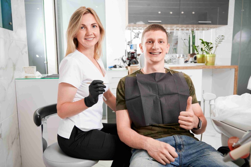 Dentist and patient smiling during a dental visit.